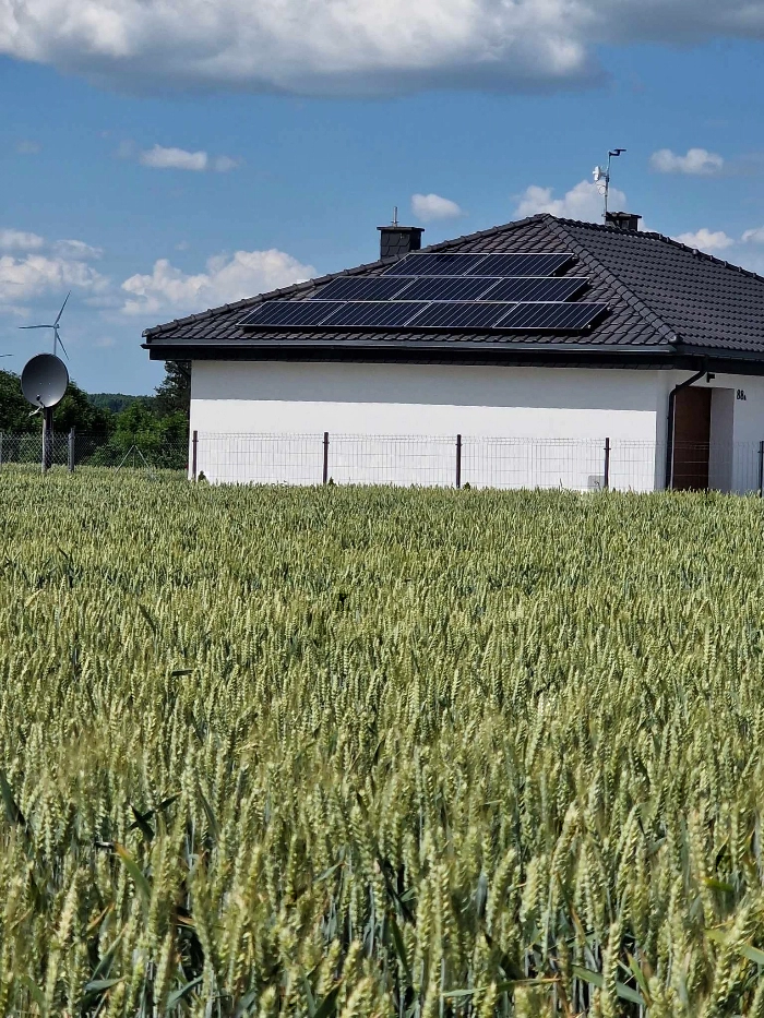 Instalacja pompy ciepła w nowoczesnym pomieszczeniu z płytkami na podłodze i ścianach.